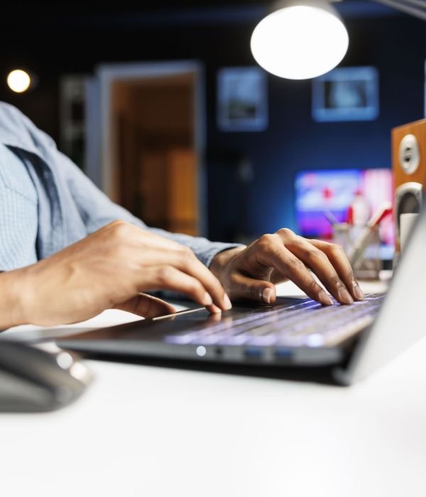 Remote tasks for company worker focusing on monthly earnings balance using legitimate financial details and web outputs. African american man manages his accounting tasks. Close up.